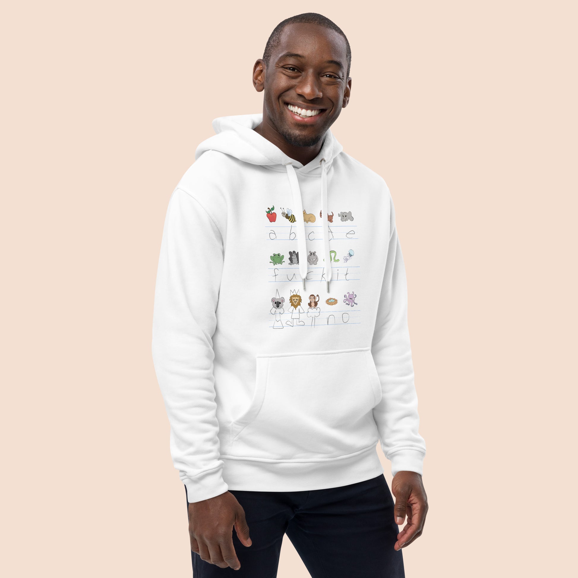 Man wearing a white hoodie with handwritten alphabet text (with a surprise) and colourful animal illustrations on a peachy beige background