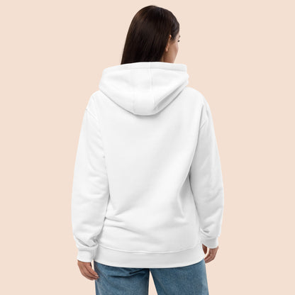 Back view of a woman wearing a white hoodie on a peachy beige background