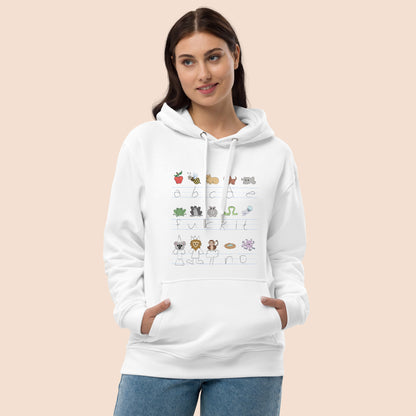 Woman wearing a white hoodie with handwritten alphabet text (with a surprise) and colourful animal illustrations on a peachy beige background