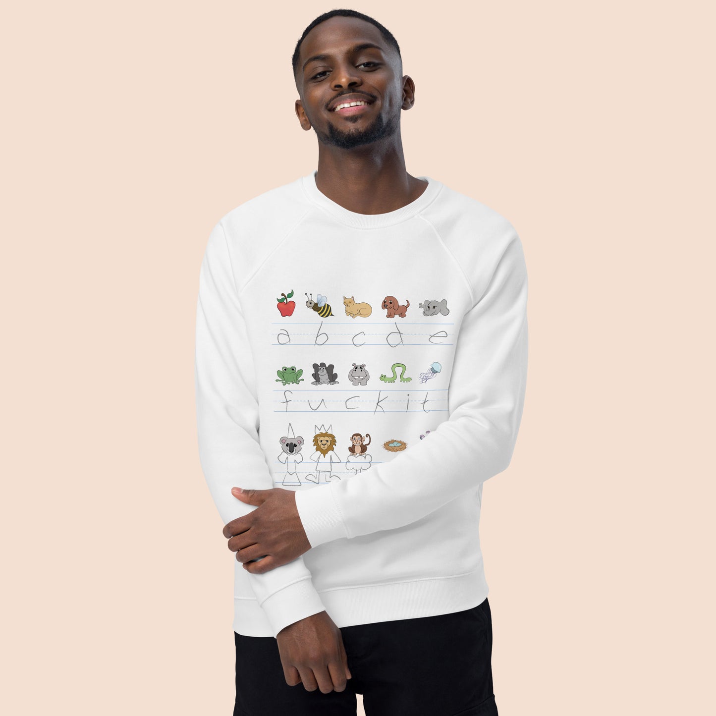 Man wearing a white sweatshirt with handwritten alphabet text (featuring a surprise) and colourful animal illustrations on a peachy beige background