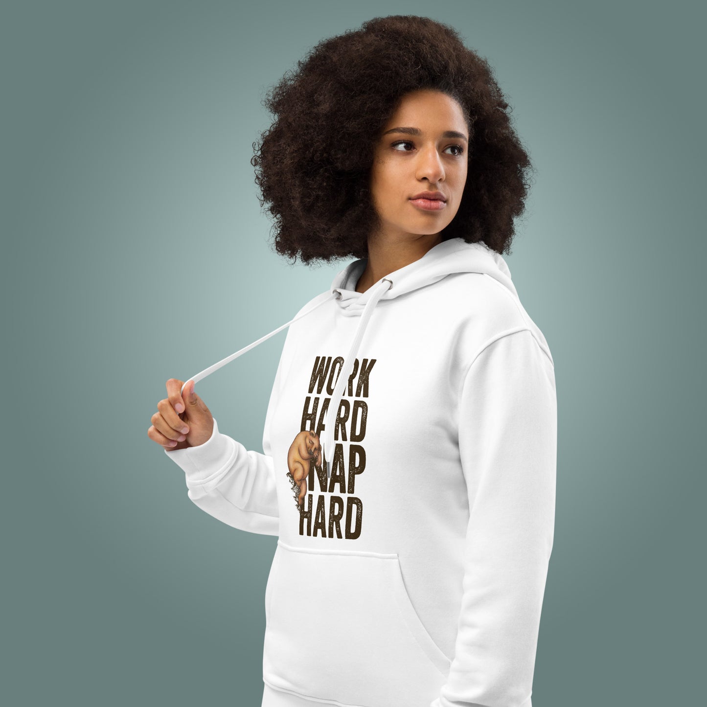 Woman wearing a white hoodie with "Work Hard, Nap Hard" design on a teal background